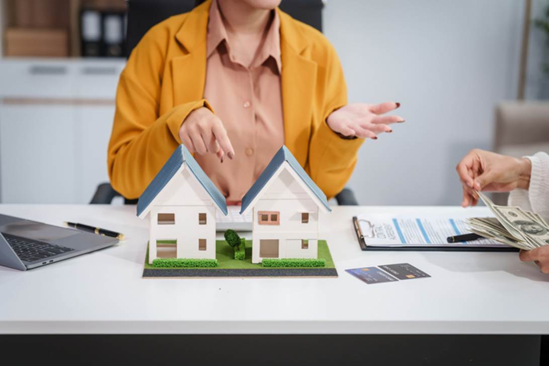 Two people sitting at a table with a model of houses
AI-generated content may be incorrect.